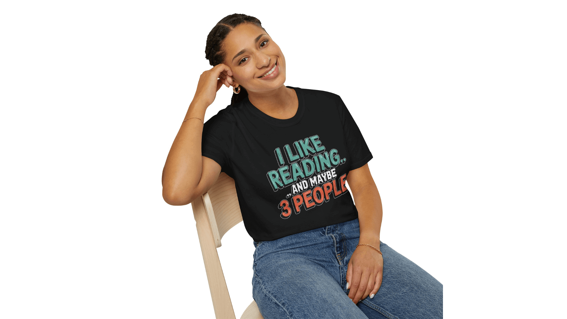 Woman sitting on a chair wearing a black t-shirt with the text "I like reading and maybe 3 people," smiling.