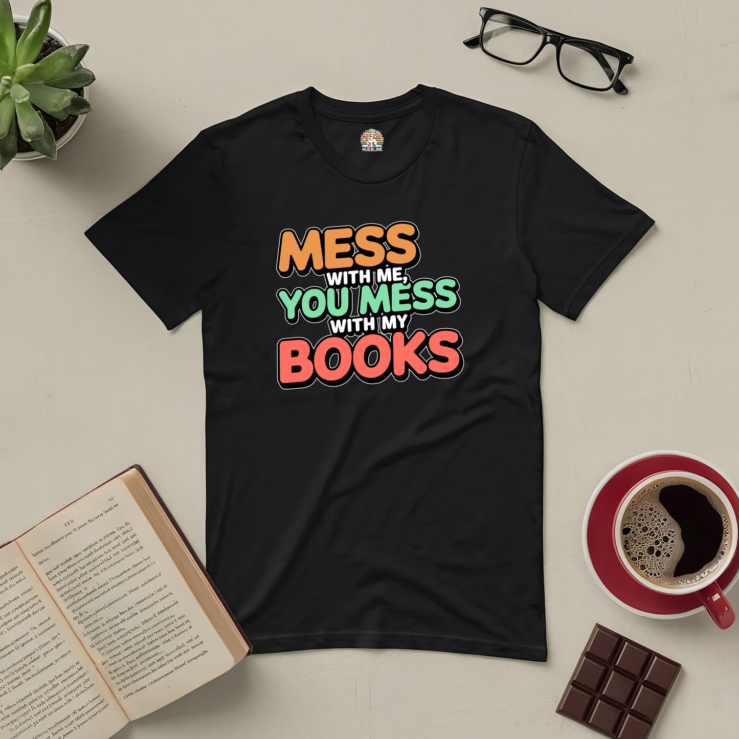 "Black tee with text 'Mess With Me, You Mess With My Books' surrounded by glasses, coffee, a book, and chocolate bar for book lovers."