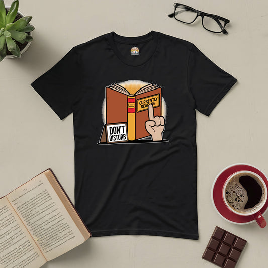 Black tee with a "Currently Reading" book and "Don't Disturb" sign, perfect for book lovers seeking uninterrupted reading time.