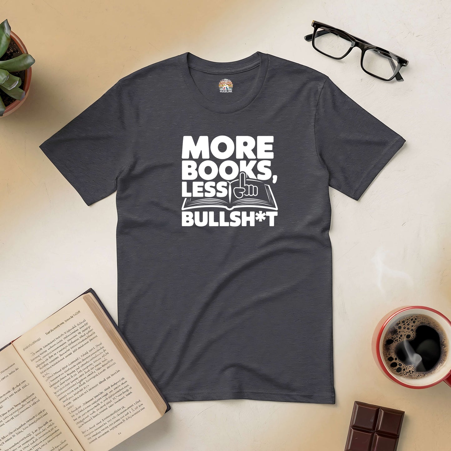 Charcoal tee with "More Books, Less Bullsh*t" text, surrounded by an open book, glasses, coffee, and chocolate.