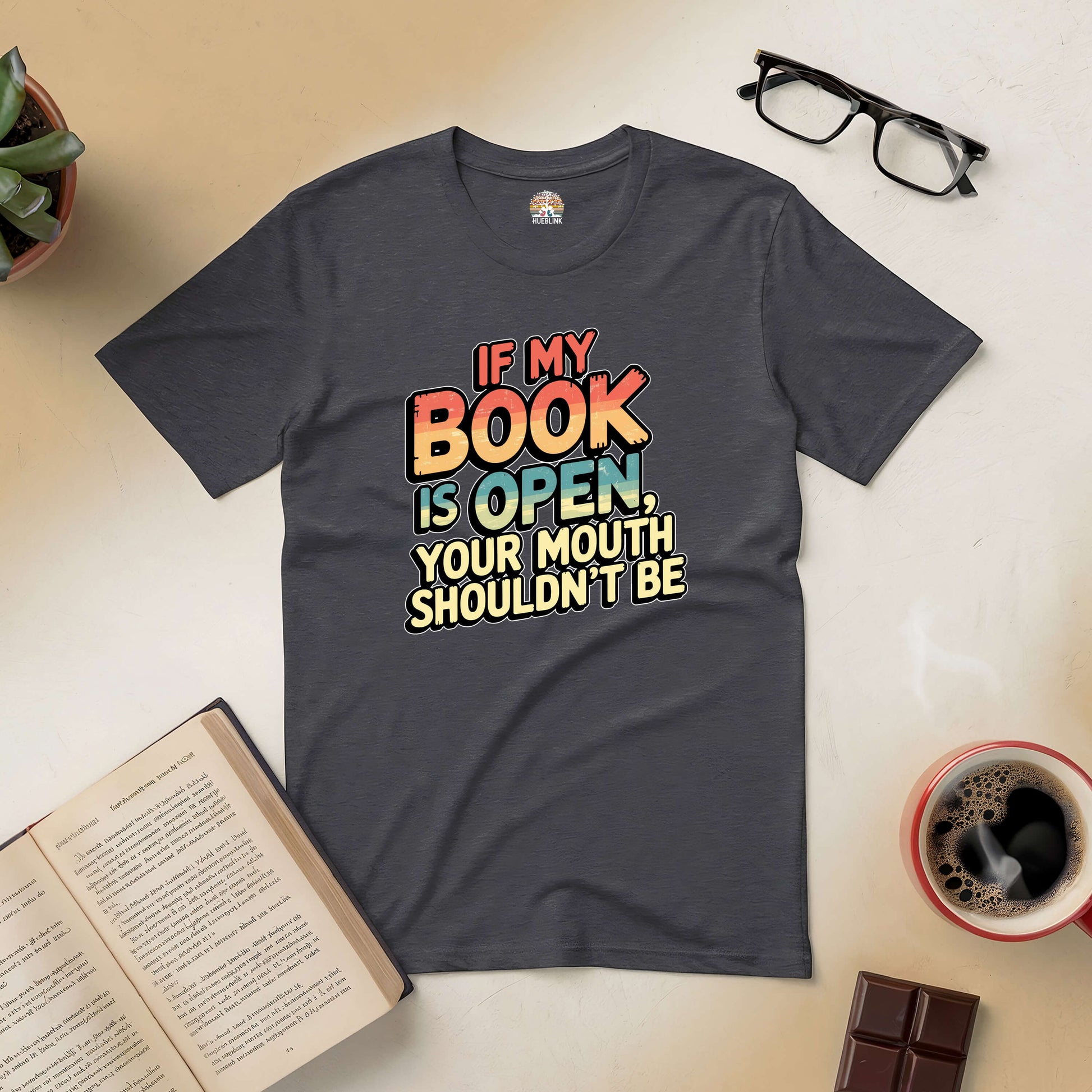 "If My Book Is Open Your Mouth Shouldn't Be Tee for book lovers on a flat lay with open book, glasses, coffee, chocolate"