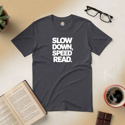 Charcoal tee with "Slow Down, Speed Read" design, surrounded by glasses, coffee, chocolate, and an open book.