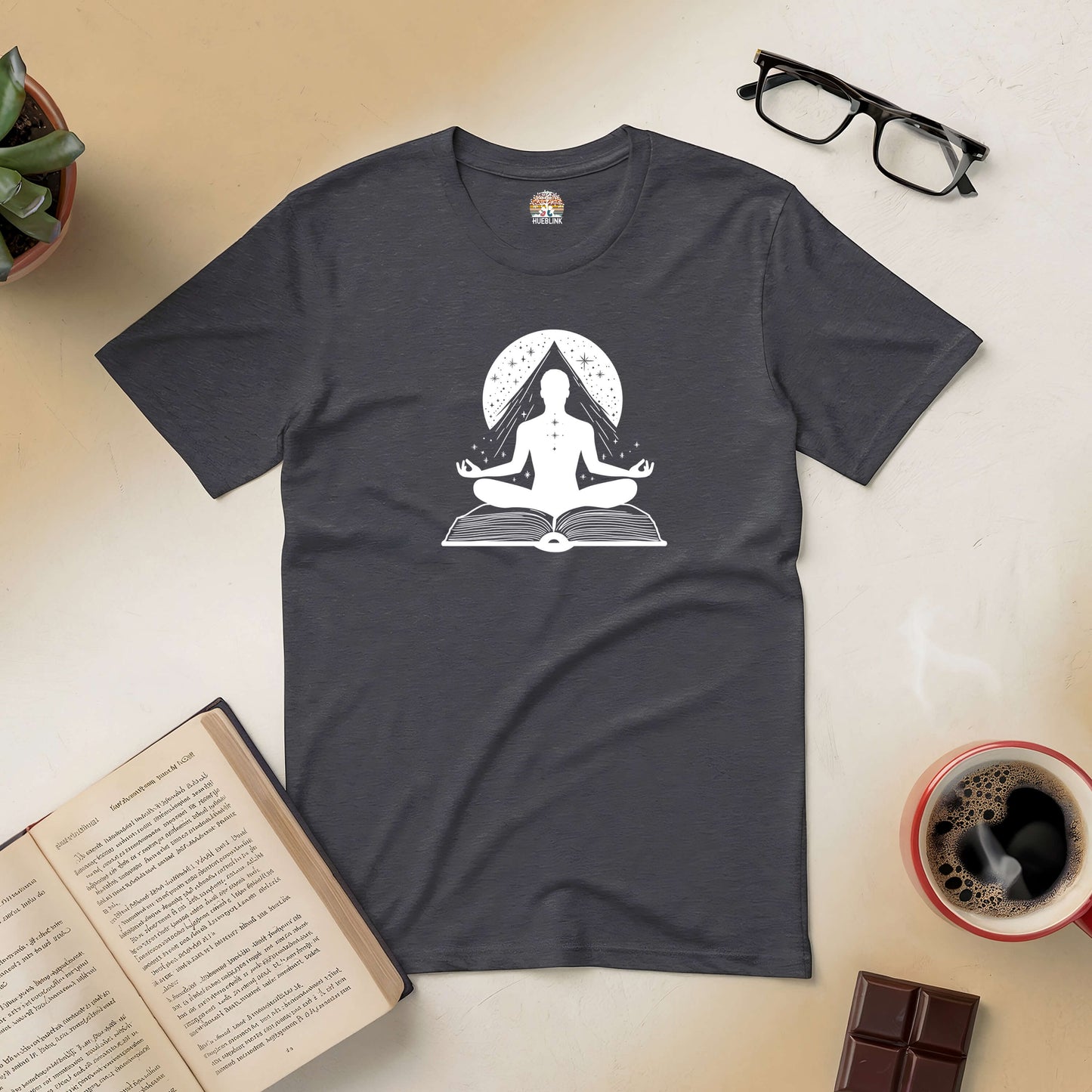 Gateway to Mindfulness Tee with meditating figure on book, surrounded by coffee, book, glasses, and chocolate.