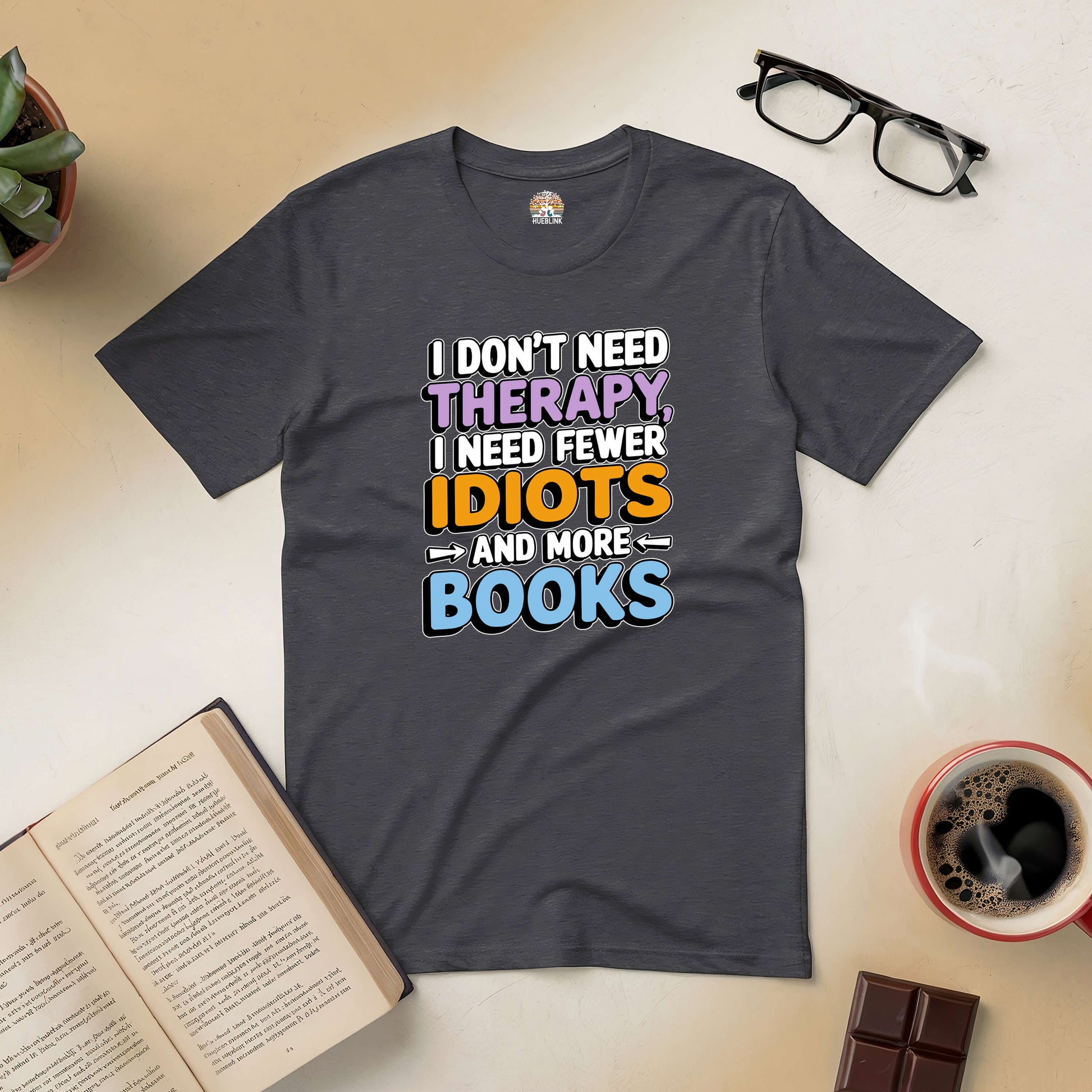 "I Don't Need Therapy, I Need Fewer Idiots and More Books" tee with books and coffee setting, perfect for book lovers.