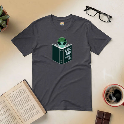 Grey "Intergalactic Habit" tee featuring alien reading a book, surrounded by coffee, chocolate, and open book on a table.