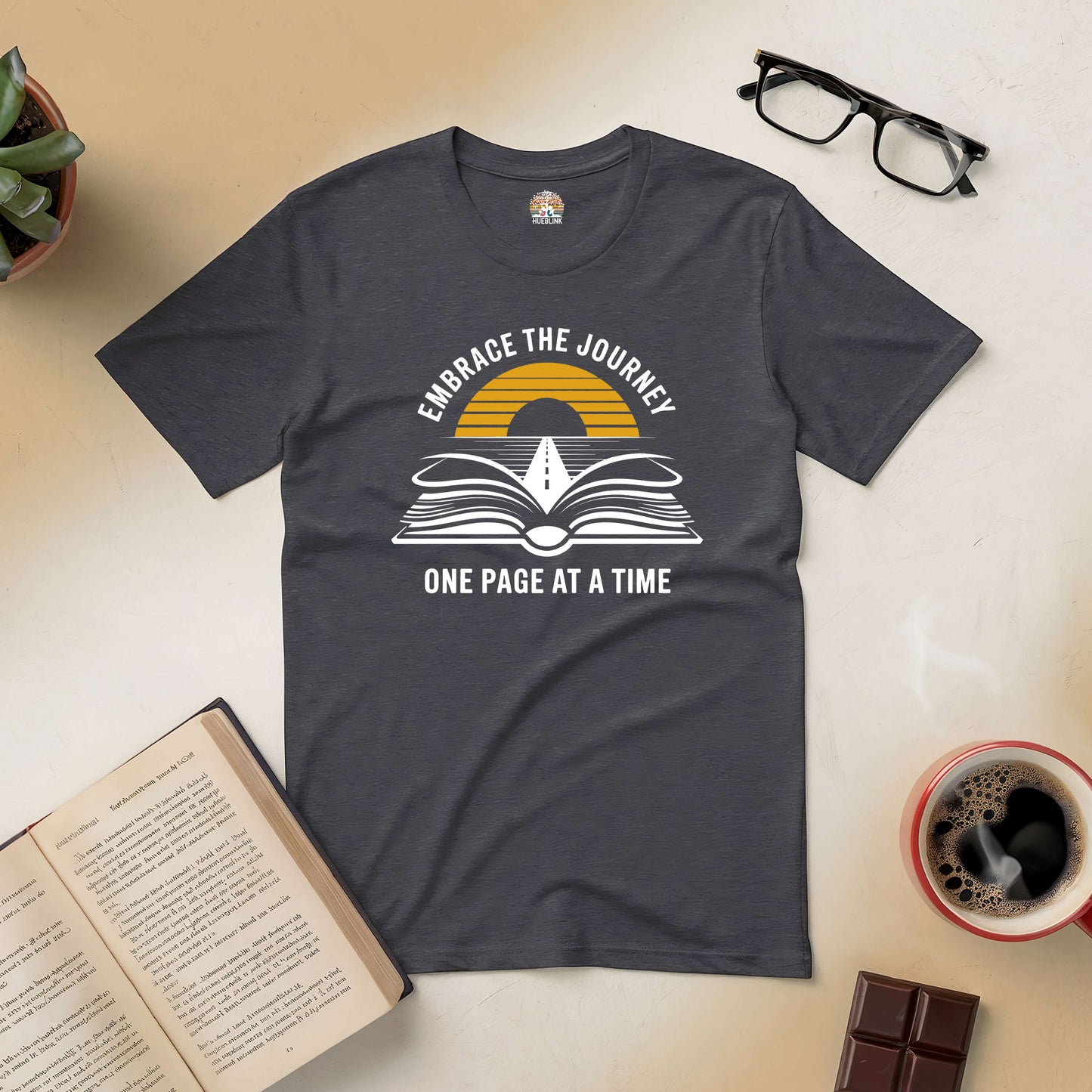 "Embrace The Journey tee with open book and sunset road design, inspiring adventure one page at a time"