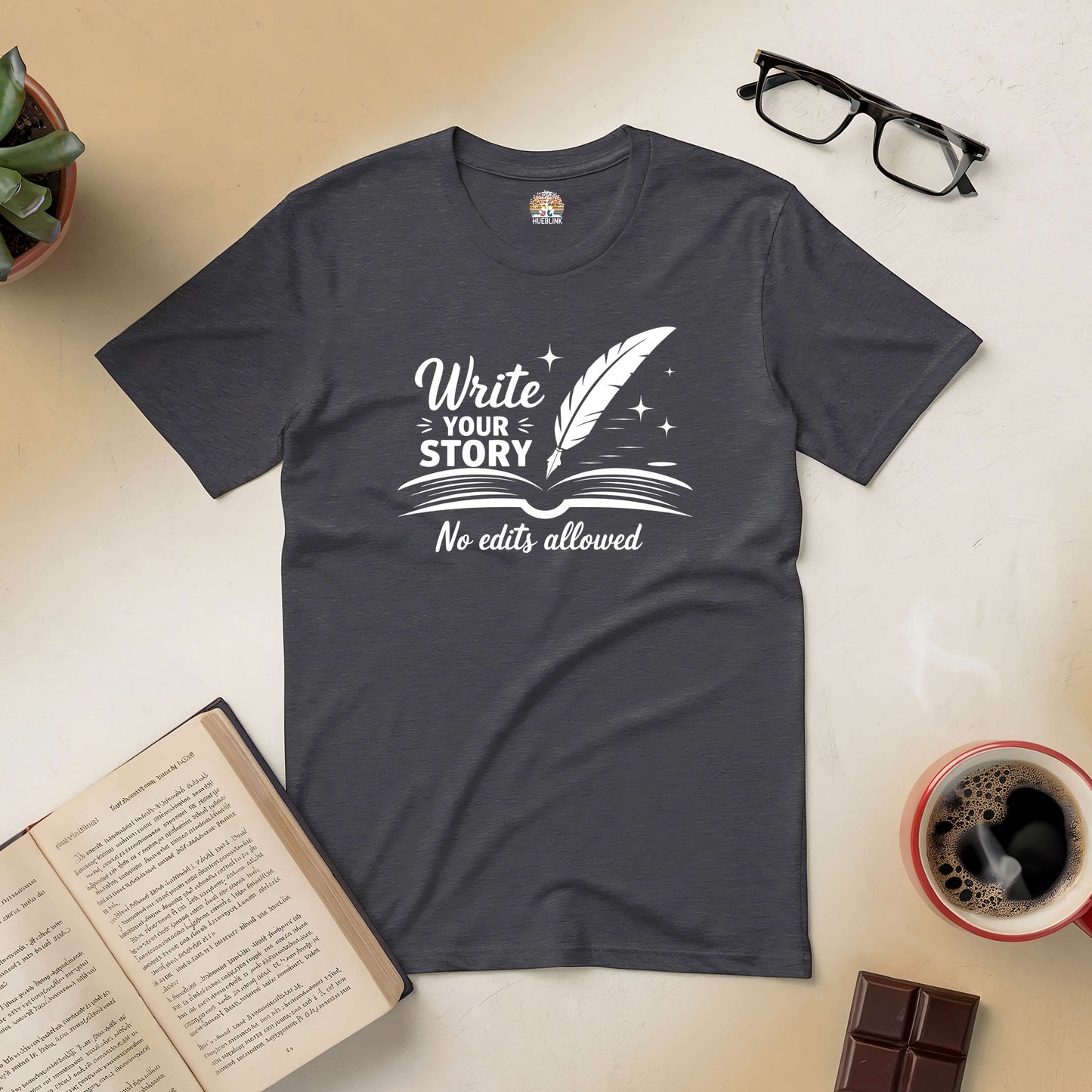 Inspirational tee with "Write Your Story, No Edits Allowed" design, surrounded by books, glasses, and a coffee cup.