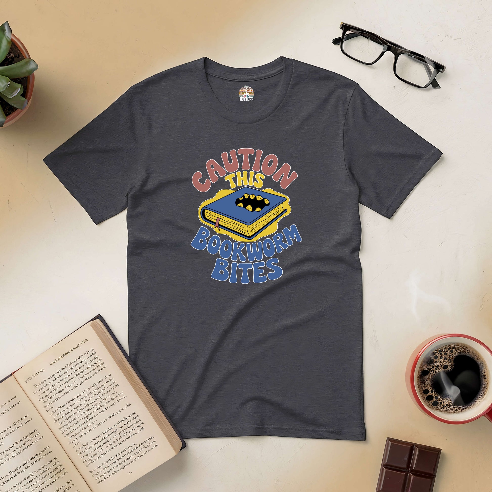 "Caution This Bookworm Bites Tee with playful design for book lovers, featuring a bold caution message and bitten book graphic"