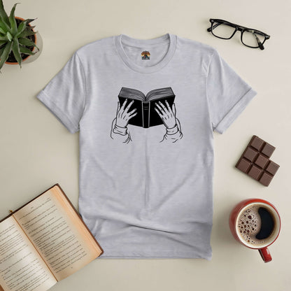 Gray "Lost in a Book" tee with a book graphic, surrounded by reading essentials like an open book, glasses, coffee, and chocolate.