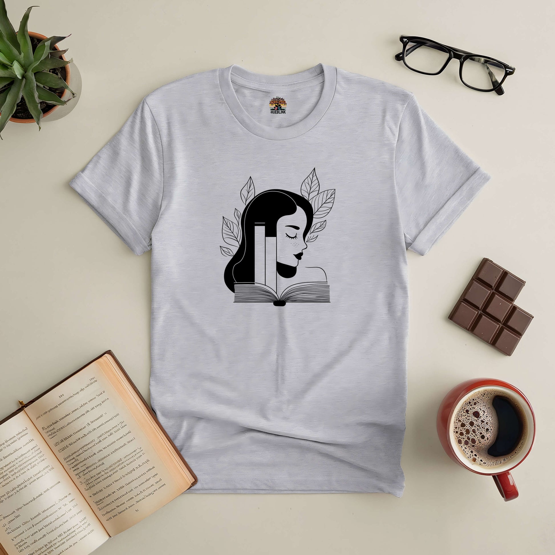 "Beauty in Every Page Tee with elegant book design, perfect for book lovers, displayed with a coffee cup, chocolate, and open book"