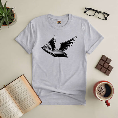 Bird of Hermes Tee with winged book design, surrounded by coffee, glasses, chocolate, and an open book on a beige surface