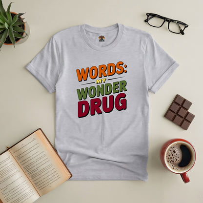 Gray Word Therapy Tee with colorful text "Words: My Wonder Drug" surrounded by books, coffee, glasses, and a plant.