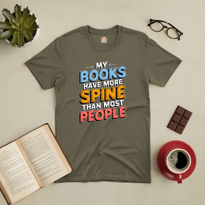 Gray t-shirt with "My Books Have More Spine Than Most People" design, surrounded by a book, coffee cup, glasses, and chocolate.