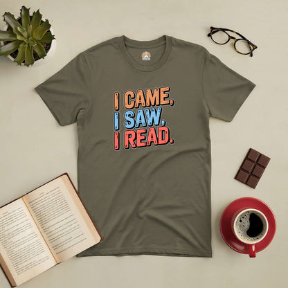 Olive green t-shirt with the phrase "I Came, I Saw, I Read" surrounded by a book, glasses, coffee, and a chocolate bar.