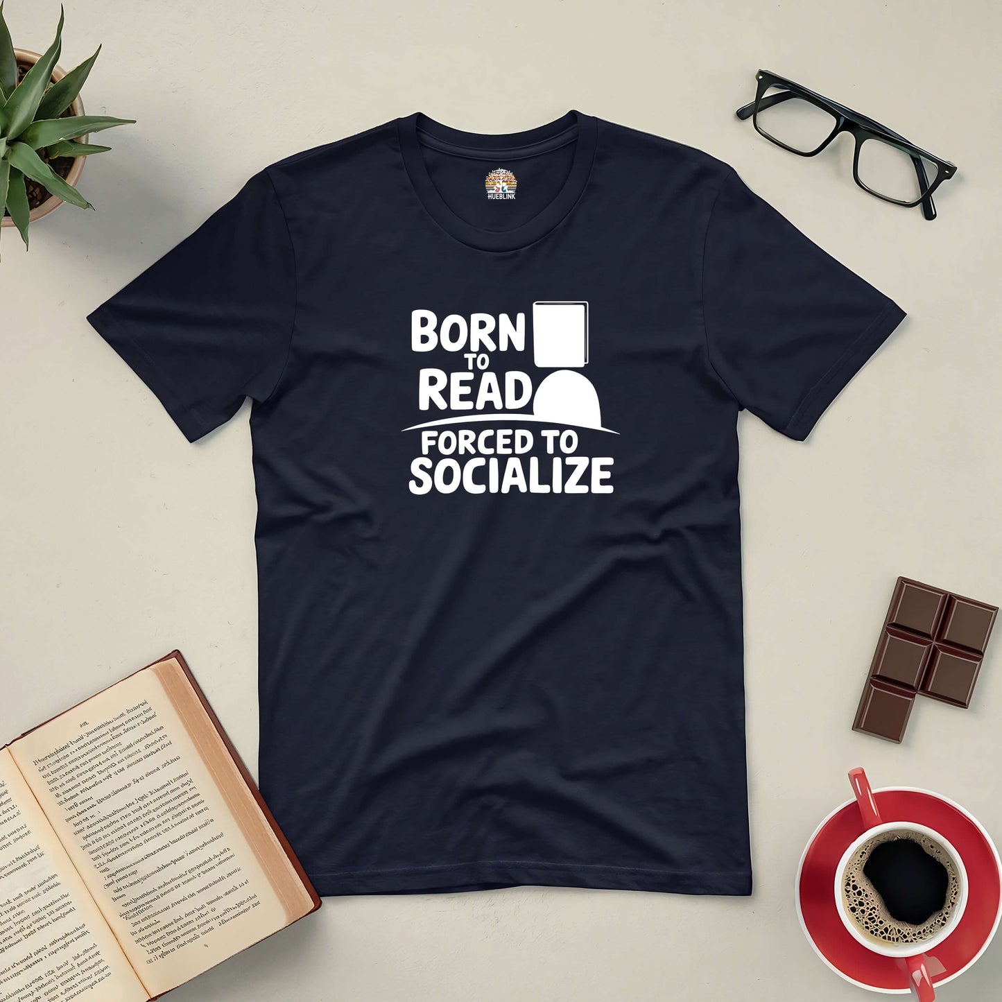 "Born to Read, Forced to Socialize Tee surrounded by book, coffee, glasses and chocolate"