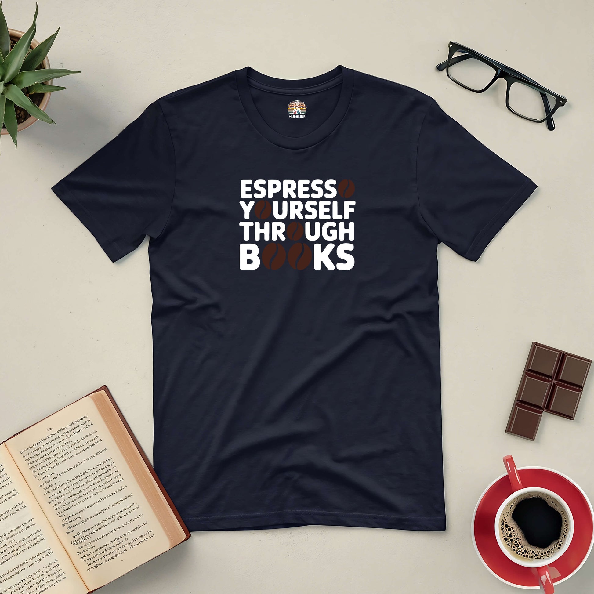 "Espresso Yourself Through Books Tee for coffee and book lovers laid flat with book, glasses, chocolate, and coffee cup"