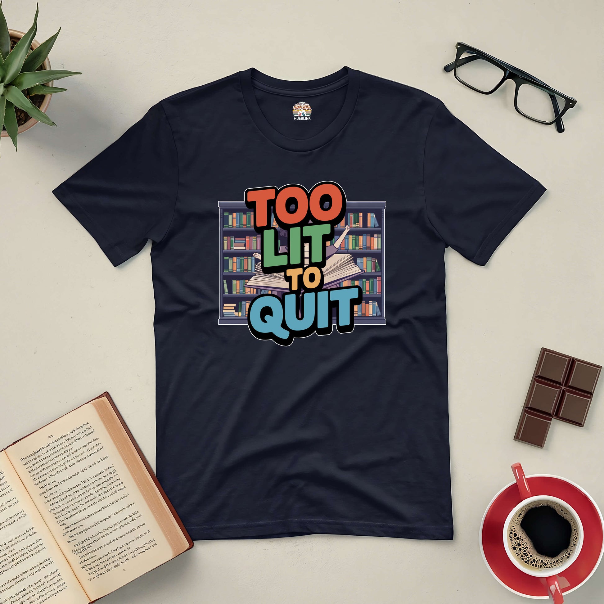 "Too Lit To Quit tee for book lovers, featuring vibrant design with books, surrounded by open book, glasses, chocolate, and coffee"