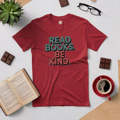 "Red 'Read Books. Be Kind.' tee with open book, coffee, glasses, and chocolate on table"