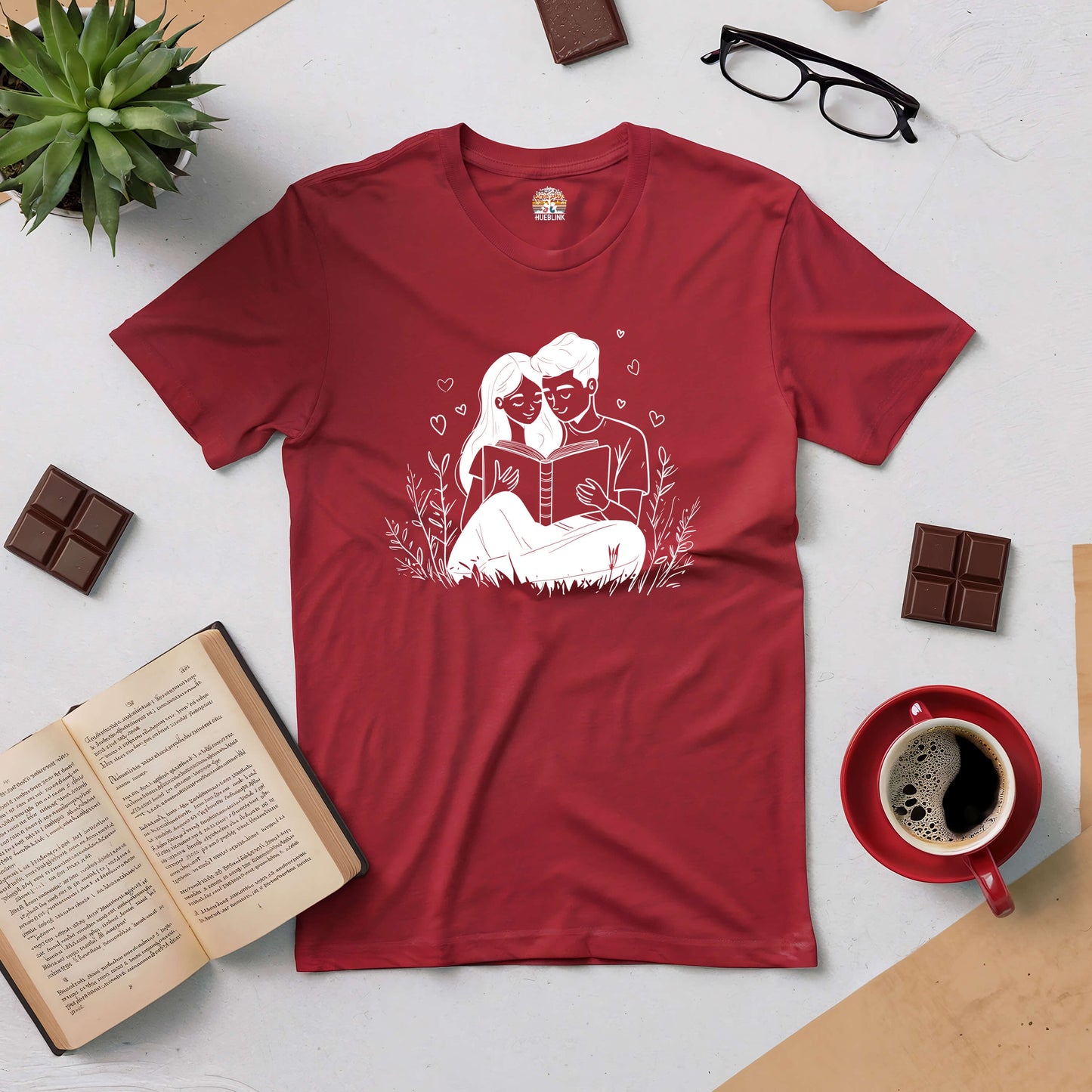 Red "Chapter of Us" tee for book-loving couples, featuring couple reading together graphic, surrounded by books and coffee.