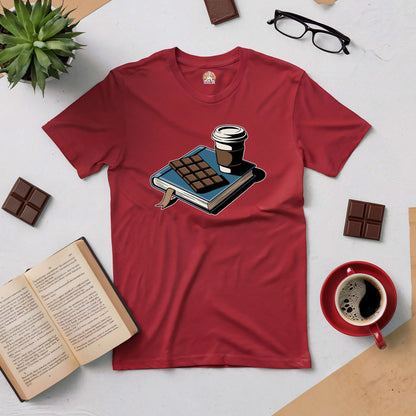 Red tee with a cozy scene of a book, coffee, and chocolate, surrounded by open book, chocolate squares, and coffee cup.