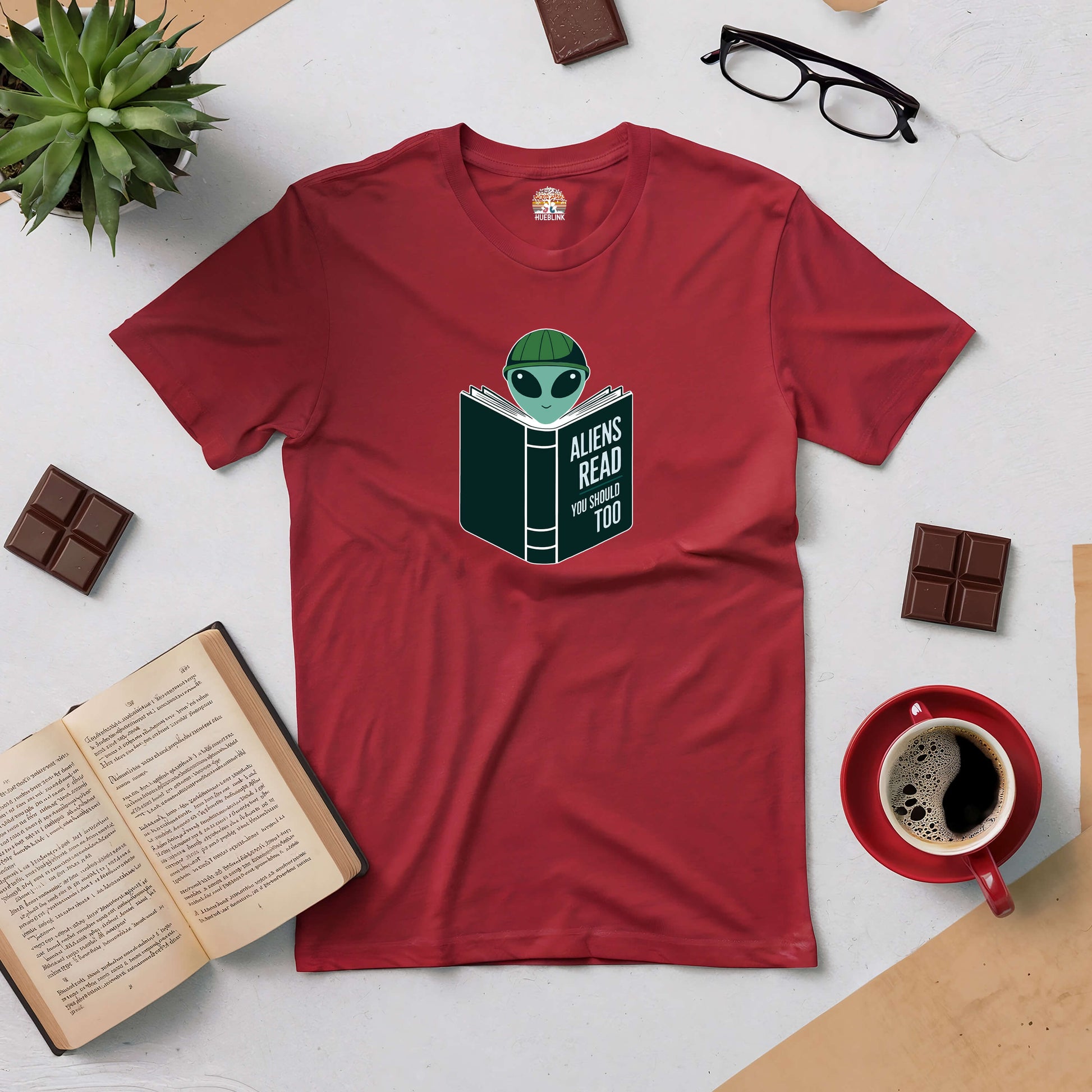 Red "Intergalactic Habit" tee with alien reading design, perfect for book lovers and sci-fi fans.