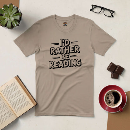 Beige tee with "I'd Rather Be Reading" text, surrounded by coffee cup, chocolate, open book, glasses, and succulent on a table.