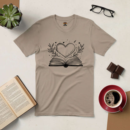 Love Stories Tee with heart and book design surrounded by coffee, glasses, open book, and plant on a desk.