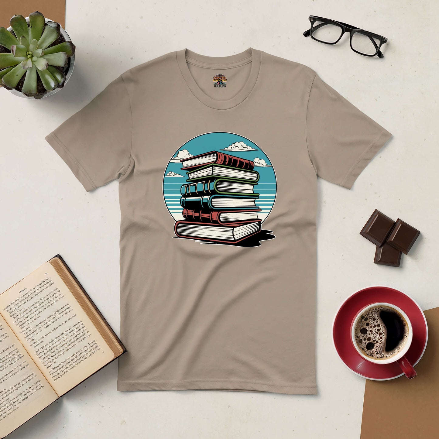 "Silent Knowledge Tee with stack of books against a sky, ideal for introspective readers seeking wisdom in peaceful moments."