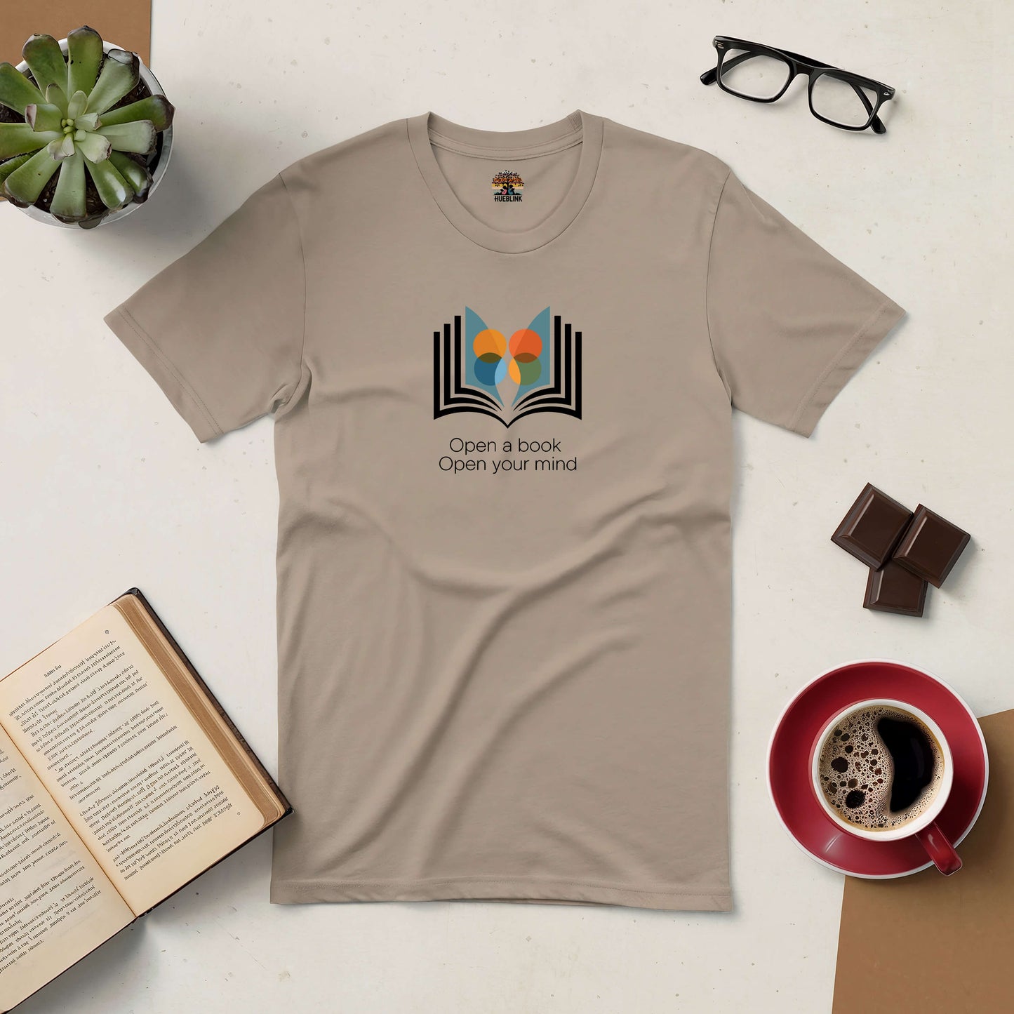 "Open a Book, Open Your Mind tee with book and coffee on table, promoting reading and curiosity"