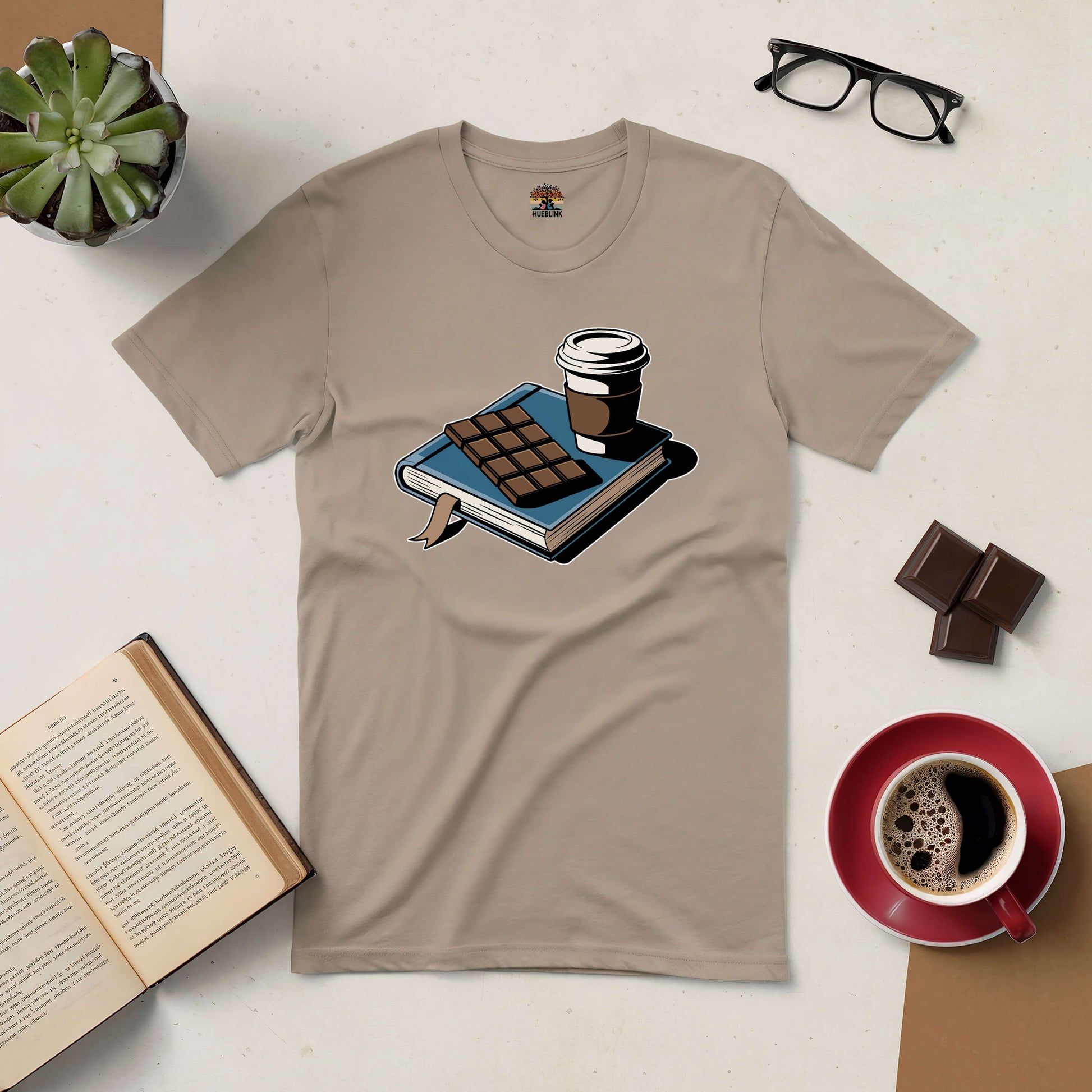 Cozy book and coffee tee with chocolate, glasses, and open book on a light surface. Perfect for indulging in sweet moments of reading.