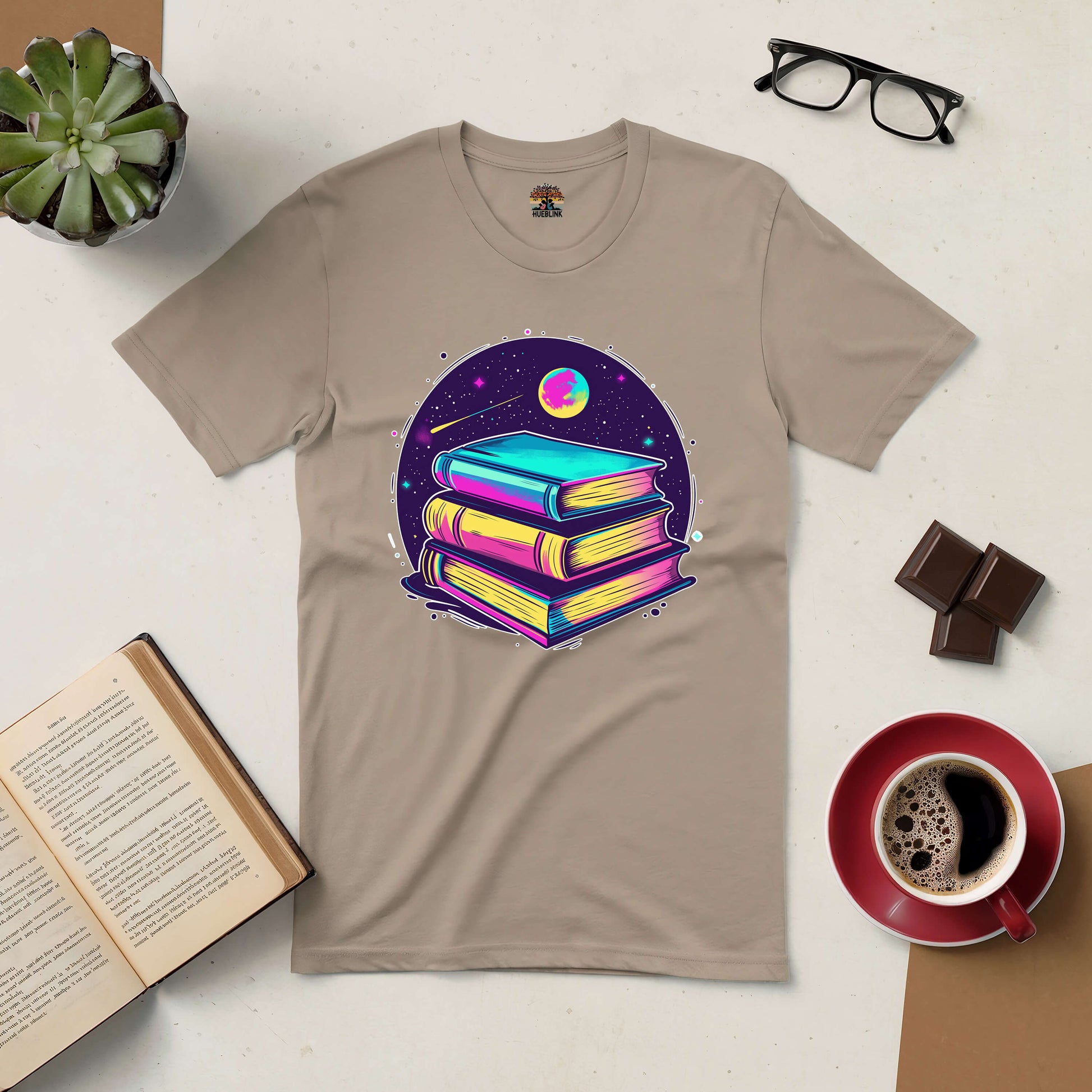 Portal to Infinite Universes Tee, featuring colorful books as gateways to imagination, surrounded by coffee and reading essentials.