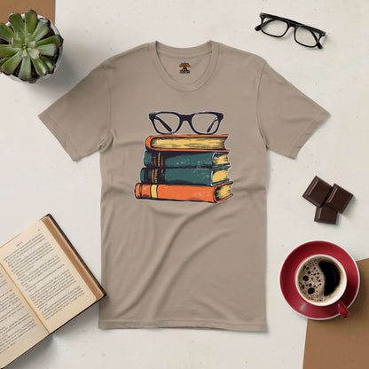 Beige t-shirt featuring a vintage book stack with glasses, styled with coffee and open book, perfect for intellectual fashion lovers.