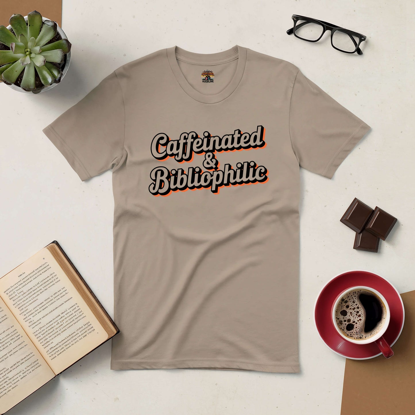 Caffeinated & Bibliophilic Tee with coffee, open book, and reading glasses - perfect for book and caffeine lovers.