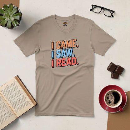 Beige t-shirt with "I Came, I Saw, I Read" text for book lovers, surrounded by coffee, glasses, chocolate, and an open book.