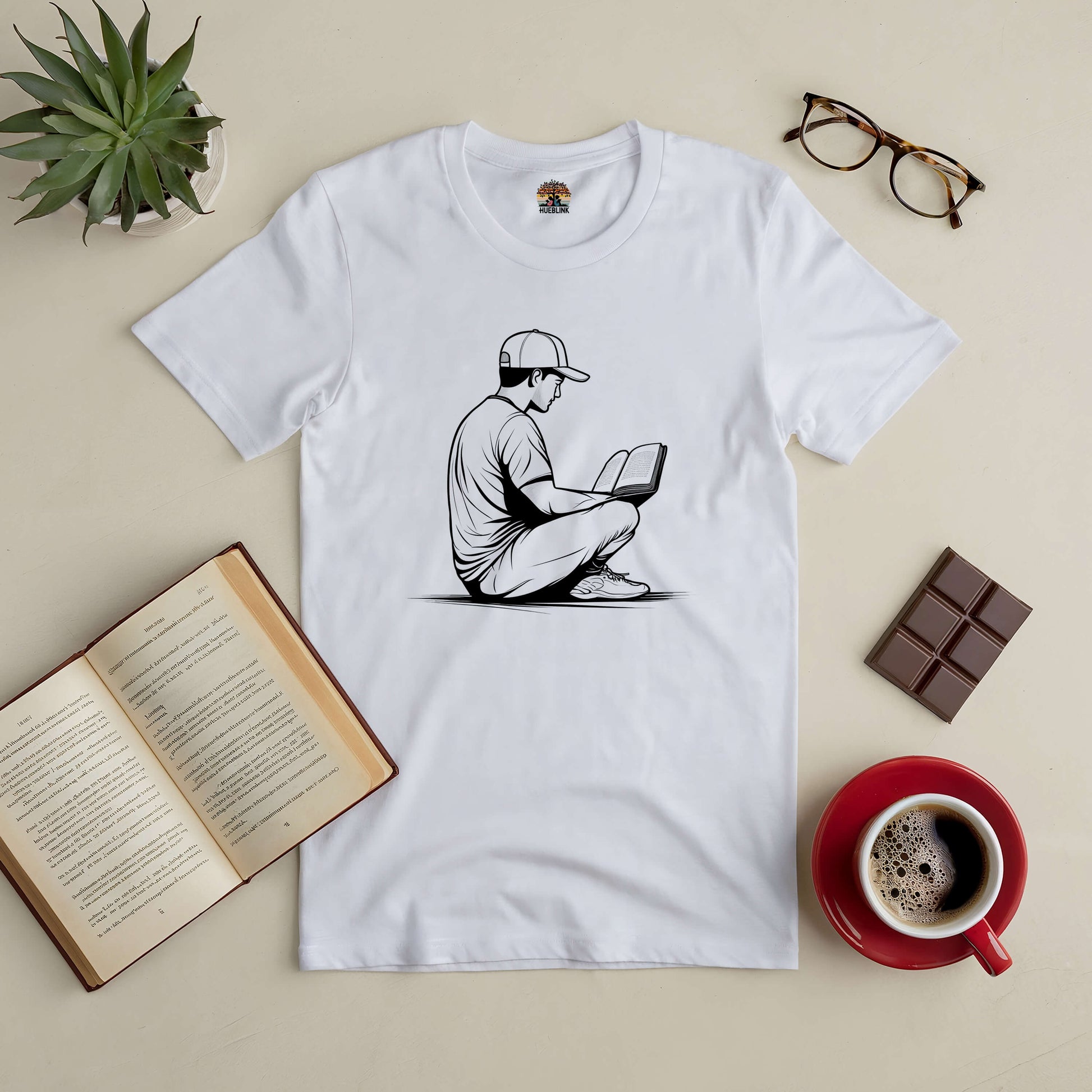 "Reading in Serenity Tee with book, coffee, and glasses for quiet introspection"