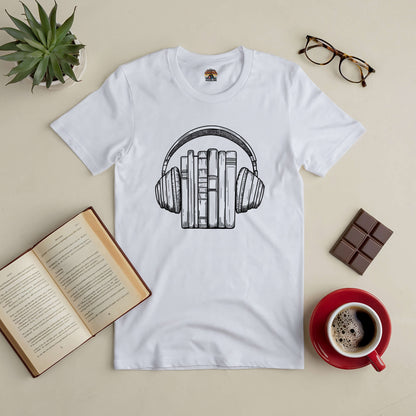 White Books & Beats Tee with headphone and book design, surrounded by a coffee cup, open book, chocolate, glasses, and a plant.