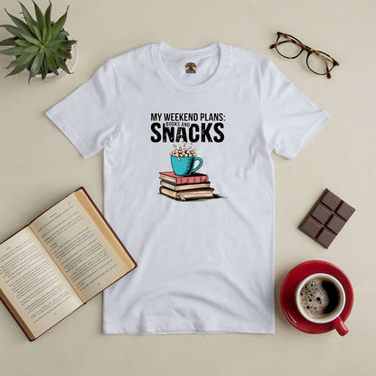 White tee with "My Weekend Plans: Books and Snacks" text, surrounded by a stack of books, a coffee cup, glasses, and chocolate.