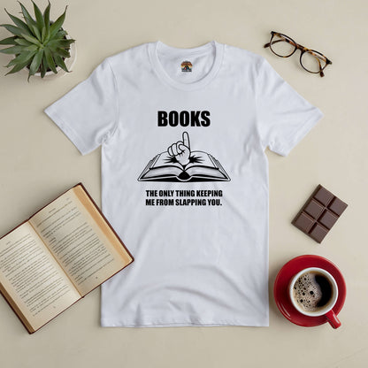 White tee with "Books: The Only Thing Keeping Me from Slapping You" text, styled with open book graphic, coffee, glasses, and plant.