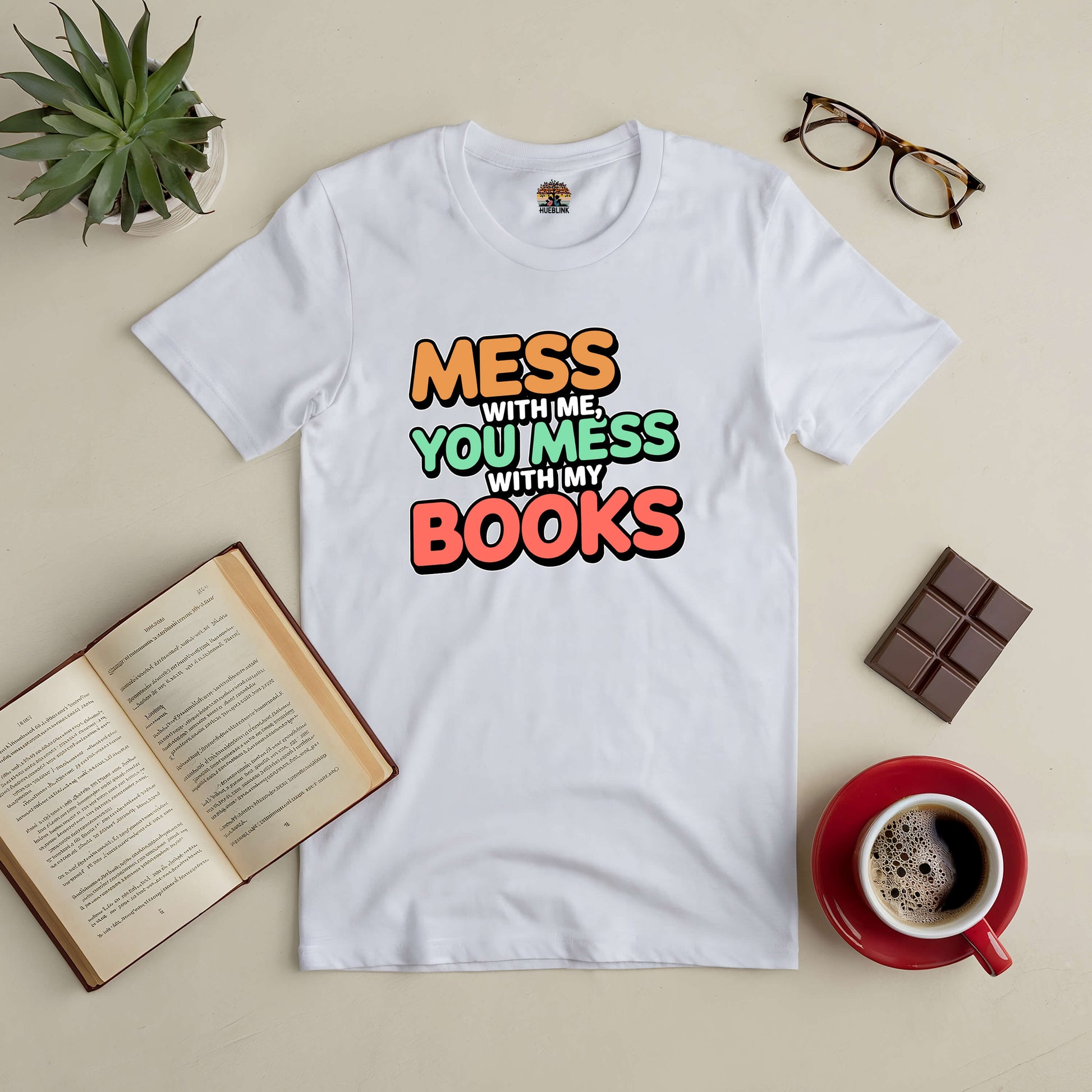 White Tee with "Mess With Me, You Mess With My Books" slogan, ideal for book lovers; surrounded by an open book, coffee, and glasses.