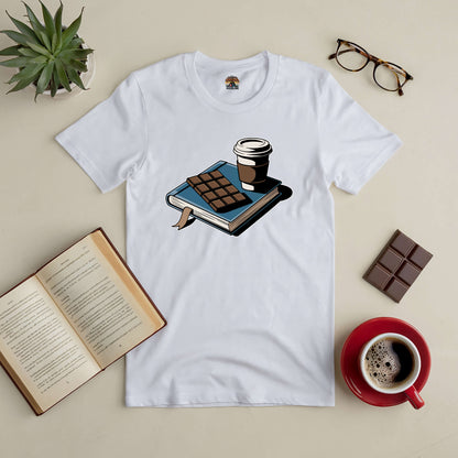 "Sweet Moments tee featuring a book, coffee, and chocolate print, surrounded by glasses and an open book on a cozy table setting"