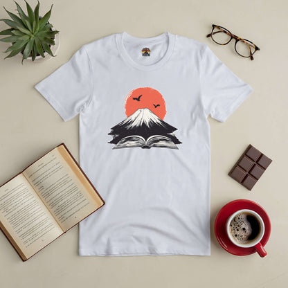 "Eruption of Imagination Tee featuring a mountain and open book design, perfect for book lovers seeking adventure and creativity."