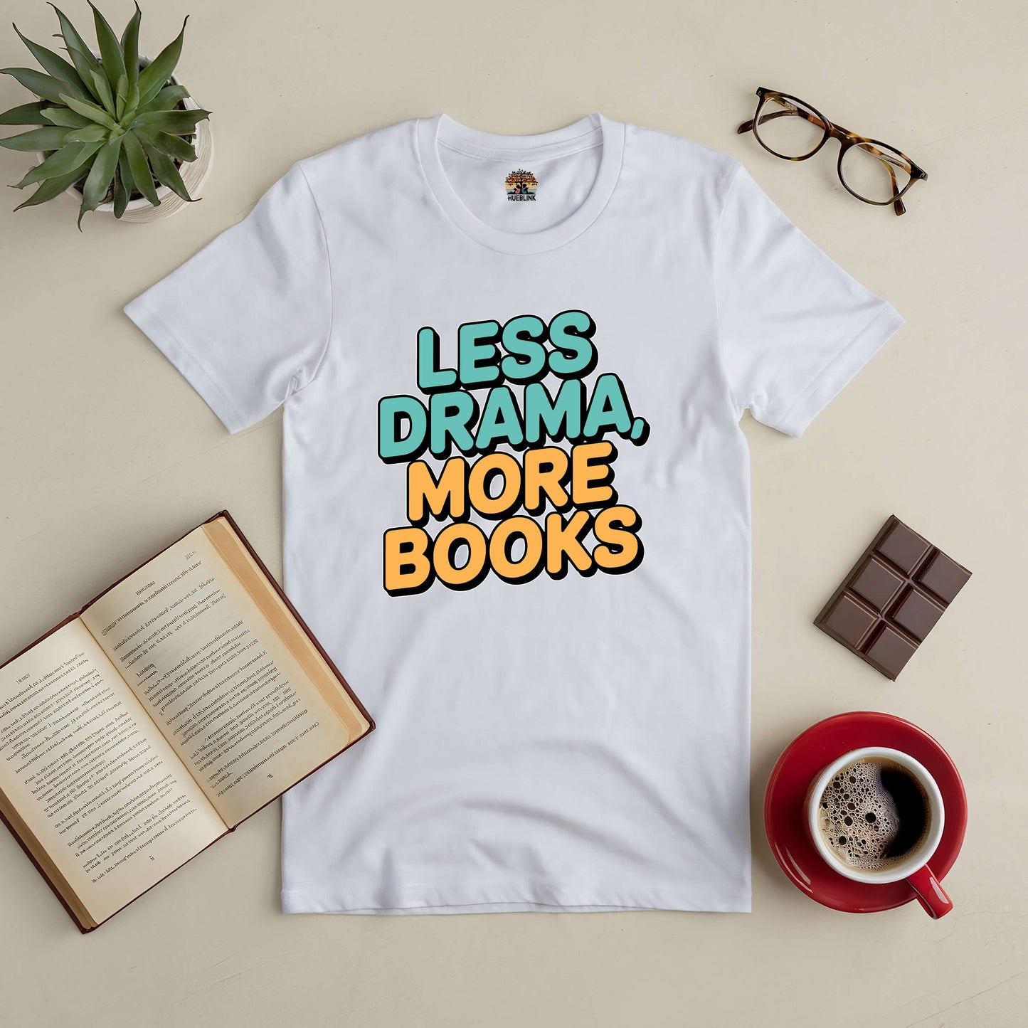 "Less Drama More Books Tee with coffee, glasses, and an open book on table."